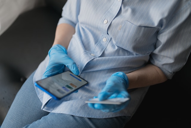 Unrecognizable female hands holding a credit card and a smartphone, paying for purchases on the Internet remotely